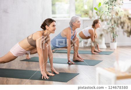 Mom, grandma and teenage daughter do rider pose Ashva sanchalanasana hatha yoga 124678380