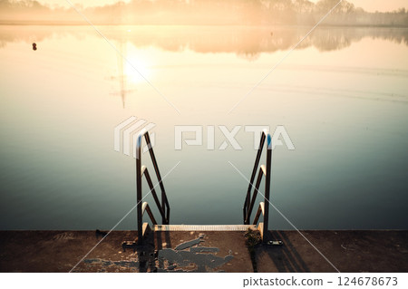 Ladder into lake in morning sunlight Ladder into lake in morning sunlight 124678673