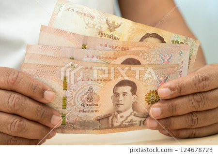 Asian woman holding Thai banknotes money, economy finance exchange trade investment. 124678723