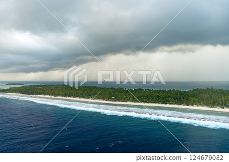 Aerial view of Tikehau atoll, French Polynesia, with cloudy sky and lagoon Aerial view of Tikehau atoll, French Polynesia, with cloudy sky and lagoon 124679082