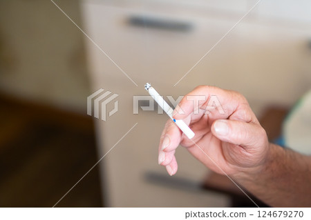 A CloseUp Detailed Perspective of a Hand Gripping a Cigarette, Capturing the Moment and Emotion A CloseUp Detailed Perspective of a Hand Gripping a Cigarette, Capturing the Moment and Emotion 124679270