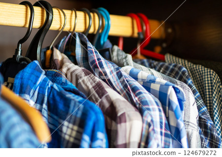 A collection of blue plaid shirts is currently hanging on a rack 124679272