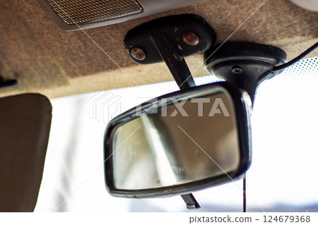 A rear view mirror that is securely attached to the roof of a car 124679368