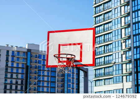 A vibrant urban basketball hoop set against the backdrop of stunning modern architecture A vibrant urban basketball hoop set against the backdrop of stunning modern architecture 124679392