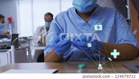 Healthcare network image over medical professionals working in clinic 124679722