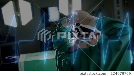 Adjusting surgical cap, medical professional in operating room with heartbeat image Adjusting surgical cap, medical professional in operating room with heartbeat image 124679769
