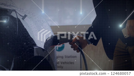 Charging electric car while using smartphone, digital network image over scene Charging electric car while using smartphone, digital network image over scene 124680057
