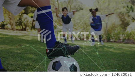 Playing soccer, children in blue uniforms with network connections image over them 124680081
