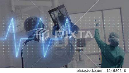 Image of cardiograph over diverse doctors inspecting xray 124680848