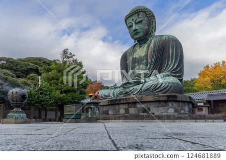 Unique perspective of the Kamakura Buddha statue framed by seasonal foliage 124681889