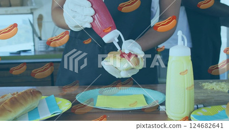 Squeezing ketchup on hot dog, person preparing food with hot dog image overlay Squeezing ketchup on hot dog, person preparing food with hot dog image overlay 124682641