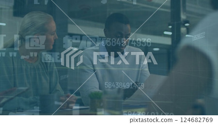 Image of colleagues discussing project details at office table with digital overlay 124682769