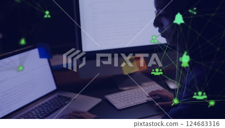 Image of network of connections with icons over biracial woman using laptop in office 124683316