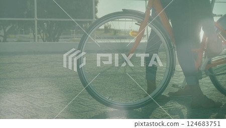 Image of light spots over biracial couple with bicycle at seaside 124683751