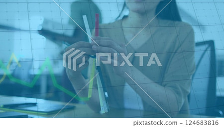 Image of financial data processing over asian businesswoman holding samples 124683816