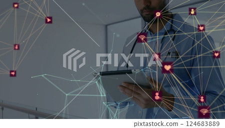 Image of globe with connections with icons over biracial male doctor with tablet Image of globe with connections with icons over biracial male doctor with tablet 124683889