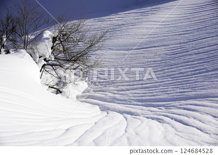 Snow patterns on mountain slopes and in valleys 124684528