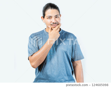 Pensive person rubbing chin with doubtful expression. Thoughtful young man rubbing his chin looking at camera isolated Pensive person rubbing chin with doubtful expression. Thoughtful young man rubbing his chin looking at camera isolated 124685098