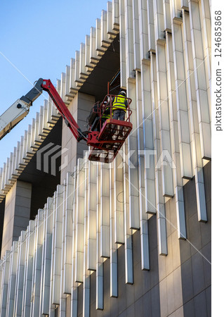 Construction crews and installers of high-rise buildings install fittings or lay electrical wiring Construction crews and installers of high-rise buildings install fittings or lay electrical wiring 124685868