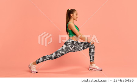 Girl holding deep lunge stretch in colorful activewear, working on leg strength and flexibility, promoting healthy movement and body balance. Girl holding deep lunge stretch in colorful activewear, working on leg strength and flexibility, promoting healthy movement and body balance. 124686486