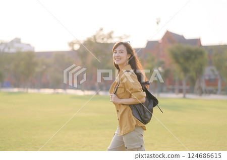 Traveler asian woman in her 30s stands bathed in the golden glow of sunset, embracing the freedom of exploration. on summer holiday weekend vacation trip in Bangkok, Thailand 124686615