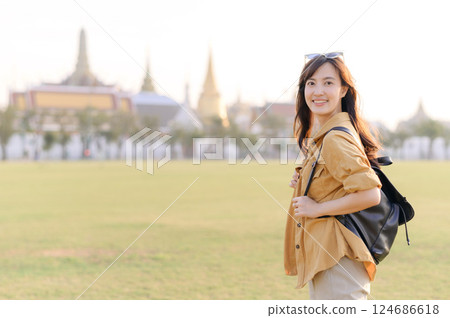 A Traveler Asian woman in her 30s exploring Wat Pra Kaew. From stunning architecture to friendly locals, she cherishes every moment, capturing it all in her heart and camera for years to come. 124686618