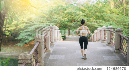 asian woman jogger, running over the bridge in public park. 124686678