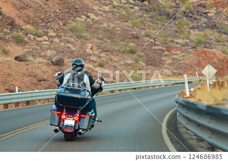 Biker couple riding chopper through mountain road 124686985