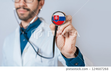 Doctor holding stethoscope with Slovakia flag. Slovakia health and care concept, Slovakia flag on stethoscope 124687268