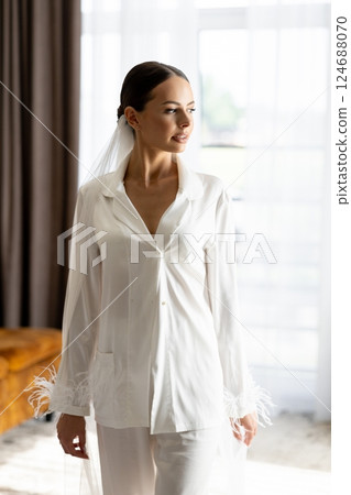 Bride wearing white pajamas and veil getting ready for wedding ceremony Bride wearing white pajamas and veil getting ready for wedding ceremony 124688070