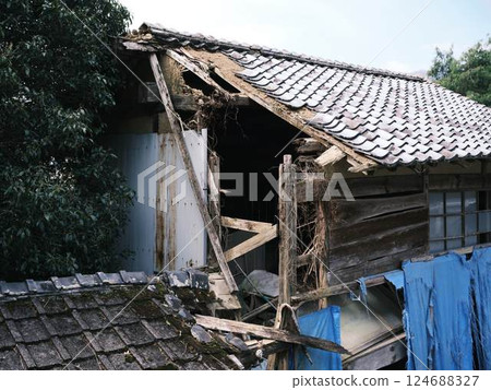Housing covered roof with blue sheet 124688327