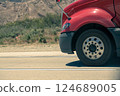 Heavy-duty vehicle tire in motion on asphalt. 124689005
