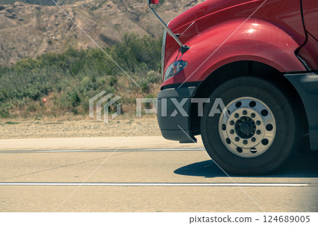Heavy-duty vehicle tire in motion on asphalt. Heavy-duty vehicle tire in motion on asphalt. 124689005