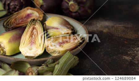 Plate full of cut purple raw artichokes closeup. Fresh italian vegetables from farmers market Plate full of cut purple raw artichokes closeup. Fresh italian vegetables from farmers market 124689084