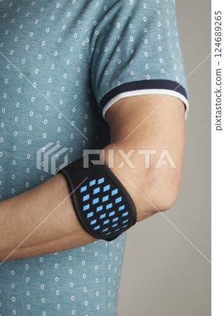 man wearing an epicondylitis bracelet 124689265
