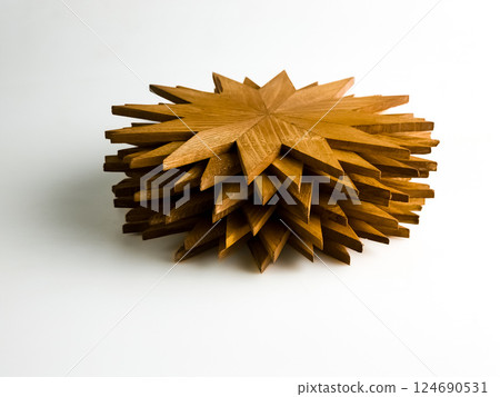 Five wooden snowflake-shaped hot plate trivets stacked in a pile isolated on white background. 124690531