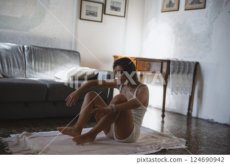 A contemplative woman immersed in her minimalist living space creating a serene atmosphere A contemplative woman immersed in her minimalist living space creating a serene atmosphere 124690942