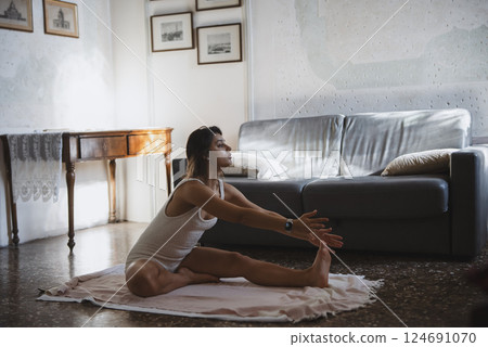 Practicing Yoga Stretching in a Serene Living Room for Relaxation and Wellbeing 124691070