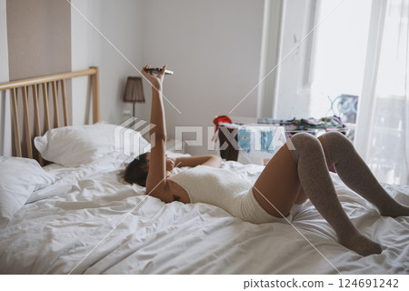 Enjoying a Relaxing Morning in a Cozy Bedroom Filled with Natural Daylight and Comfort 124691242