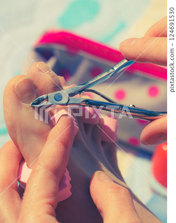 Woman trimming cuticles before pedicure Woman trimming cuticles before pedicure 124691530