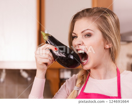 Woman holding biting eggplant. 124691664