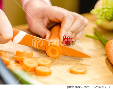 Woman cutting carrot on kitchen board 124691704