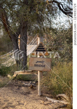 A yellow, bilingual road sign indicates a bridge ahead with an icon of a bridge and a words in both English and Arabic languages. Dubai, Mushrif park, 16.02.25, UAE A yellow, bilingual road sign indicates a bridge ahead with an icon of a bridge and a words in both English and Arabic languages. Dubai, Mushrif park, 16.02.25, UAE 124691724