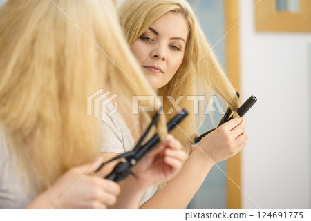 Woman using hair curler 124691775