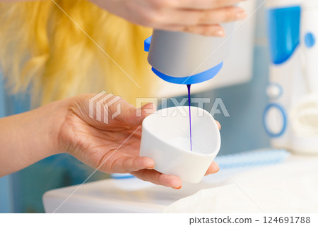 Woman pouring purple hair dye or shampoo Woman pouring purple hair dye or shampoo 124691788