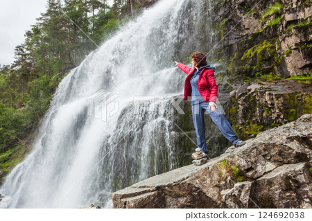 Tourist woman at waterfall Svandalsfossen, Norway Tourist woman at waterfall Svandalsfossen, Norway 124692038