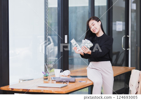 Beautiful young woman holding us dollar money. business, finance, saving, banking and online shopping concept. 124693005
