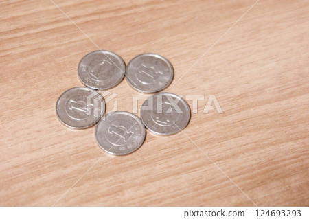 close up of five Japanese yen coins in value one dollar on a wooden table with copy space 124693293