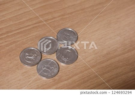 close up of five Japanese yen coins in value one dollar on a wooden table with copy space 124693294
