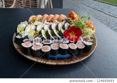 Colorful Japanese Sushi Platter with Variety of Rolls and Edible Flowers 124693683